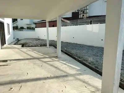 a white building with columns in the middle of a sidewalk at \u5de5\u4e1a\u4f4f\u5bb6 in Lahat