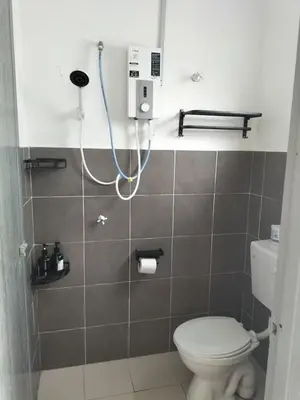 a bathroom with a white toilet and a shower at Lahat Homestay in Lahat
