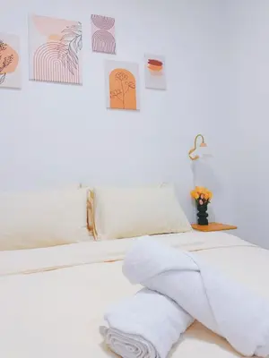 a bedroom with a bed with towels on it at Cozy Homestay 6-10pax Double storey in Bukit Mertajam