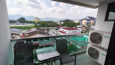 a balcony with a chair and a view of a city at Kinta Riverfront Apartment Riverview Apartment in Ipoh