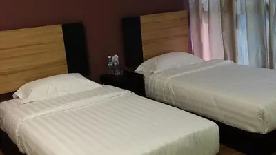 two beds sitting next to each other in a bedroom at Amigo Hotel in Seri Iskandar
