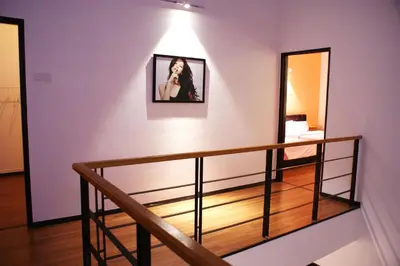 a room with a staircase with a mirror and a woman on the wall at Shamrock Seaview 11 Villa in Batu Ferringhi