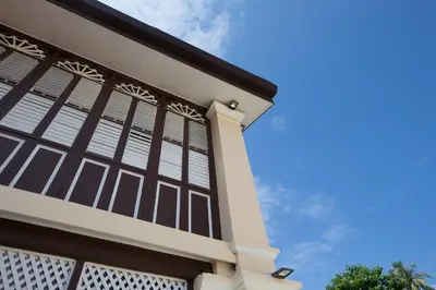 a house with white windows and a blue sky at Jawi Peranakan Mansion in George Town