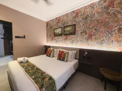 a bedroom with a bed and a colorful wall at RARE Heritage House in George Town