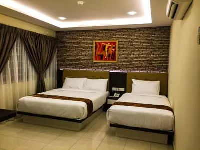 a bedroom with two beds and a brick wall at Louis Hotel in Taiping