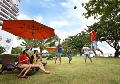 a group of people playing with a ball in a park at Lexis Suites Penang in Bayan Lepas