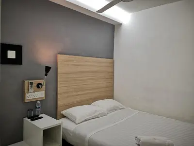a bedroom with a bed and a nightstand next to it at Dragon Door Hotel in Sitiawan