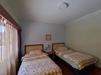 a bedroom with two beds and a window at Mary Apt @ Equatorial Hill Resort in Cameron Highlands