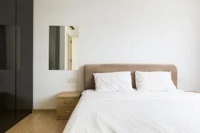 a bedroom with a large white bed with a mirror at 118 Residences by Travovo in George Town
