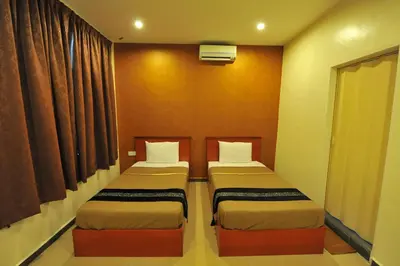 two beds in a small room with curtains at Gurney Inn in George Town