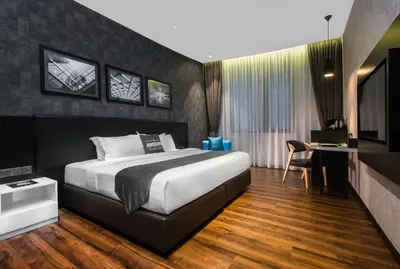 a bedroom with a bed and a desk and a tv at Iconic Hotel in Bukit Mertajam