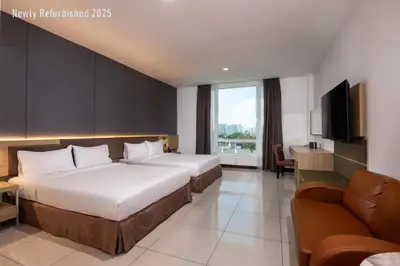 a hotel room with two beds and a television at One Pacific Hotel and Serviced Apartments in George Town