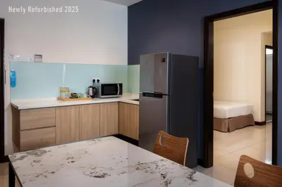 a kitchen with a stainless steel refrigerator and a table at One Pacific Hotel and Serviced Apartments in George Town