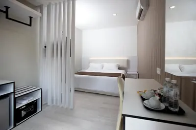 a room with a bed and a table and a kitchen at Gurney Lodge in George Town