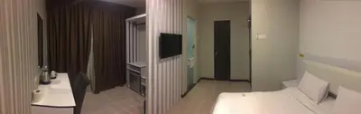 a bathroom with a bed and a television in a room at Gurney Lodge in George Town