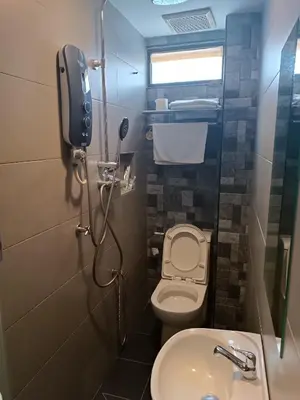 a small bathroom with a toilet and a sink at Gurney Lodge in George Town