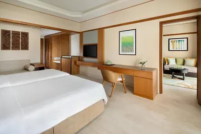 a bedroom with a bed and a desk and a television at Shangri-La Rasa Sayang, Penang in Batu Ferringhi