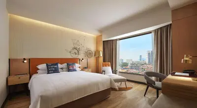 a hotel room with a bed and a large window at JEN Penang Georgetown by Shangri-La in George Town