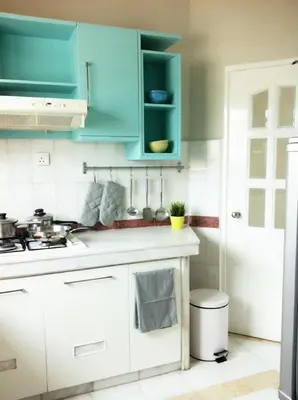 a kitchen with blue cabinets and a white counter top at Century Bay Private Residences in Bayan Lepas