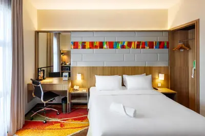 a hotel room with a bed and a desk and a desk at Eastin Hotel Penang in Bayan Lepas