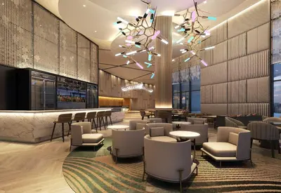 a hotel lobby with chairs and tables and a chandelier at Eastin Hotel Penang in Bayan Lepas