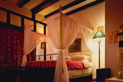 a bedroom with a canopy bed with curtains at The Smokehouse Hotel & Restaurant Cameron Highlands in Cameron Highlands