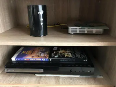 a shelf with two dvds and a drink at The Majestic condo Ipoh in Ipoh