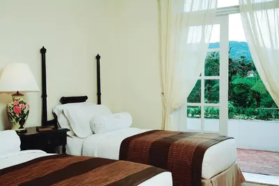 a hotel room with two beds and a window at Cameron Highlands Resort - Small Luxury Hotels of the World in Cameron Highlands