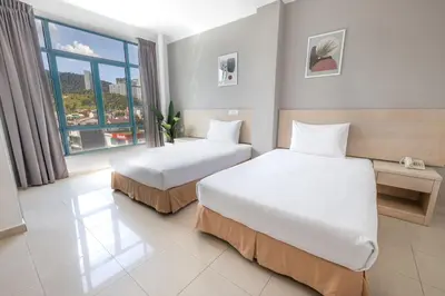 a hotel room with two beds and a window at Golden View Serviced Apartments in George Town