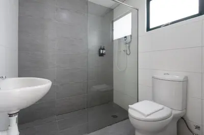 a bathroom with a white toilet and a sink at Golden View Serviced Apartments in George Town