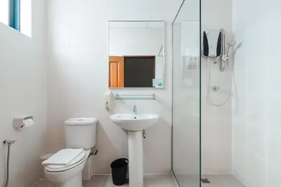 a white bathroom with a toilet and a sink at Golden View Serviced Apartments in George Town