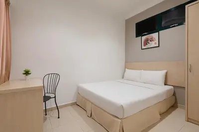 a bedroom with a bed and a desk and a chair at Golden View Serviced Apartments in George Town