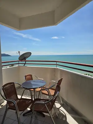a table and chairs on a balcony with the ocean at Green Ocean Seaview Apartment in Batu Ferringhi