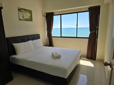 a bedroom with a bed with a large window at Green Ocean Seaview Apartment in Batu Ferringhi