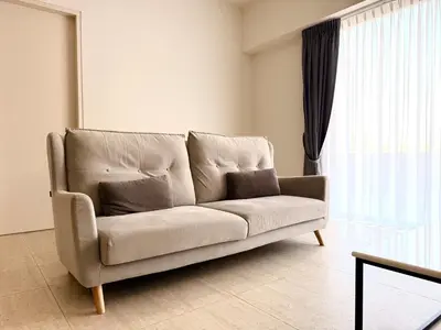 a living room with a couch in front of a window at By The Sea Suites - Managed by SDBMS in Batu Ferringhi