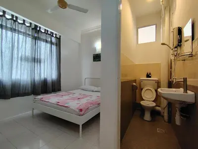 a bathroom with a bed and a sink and a toilet at Penang Tg Bungah Permai Ria Apartment in Tanjung Bungah