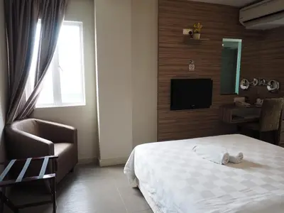a bedroom with a bed and a chair and a television at Mornington Hotel Medan Ipoh in Ipoh