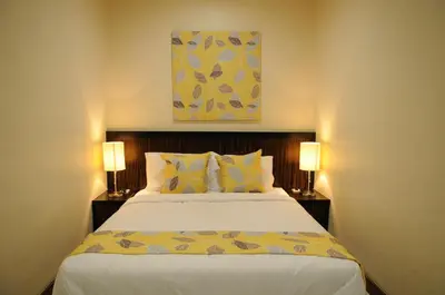 a bedroom with a large bed with two lamps at Marina Oriental Hotel in Butterworth