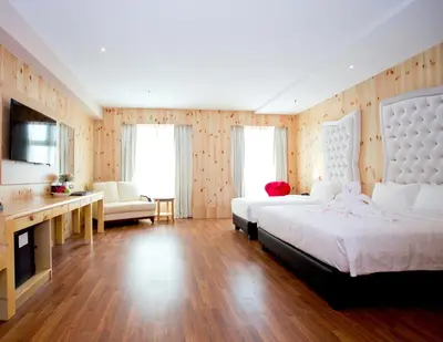 a large bedroom with two beds and a television at Vouk Hotel Suites, Penang in George Town