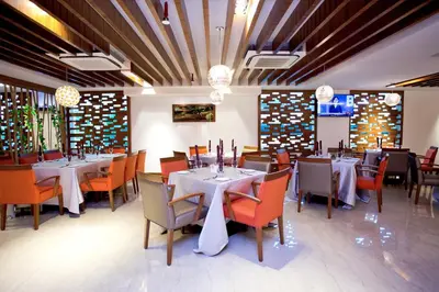 a dining room with tables and chairs and chandeliers at Vouk Hotel Suites, Penang in George Town
