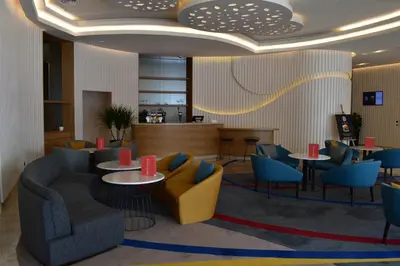 a lobby with tables and chairs and a bar at Novotel Taiping in Taiping