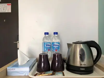 two bottles of water are sitting next to a toaster at Double Happiness Hotel in Seri Manjung