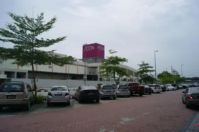 a parking lot with cars parked in front of a building at Double Happiness Hotel in Seri Manjung