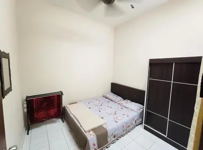 a small bedroom with a bed in the corner at Homestay selinsing in Simpang Ampat Semanggol