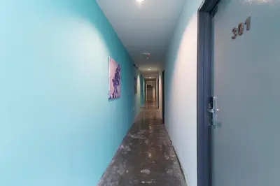 a hallway with blue walls and a door at Clover Hotel Ipoh in Ipoh