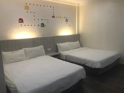a room with two beds and a wall with a climbing wall at Tambun Inn Hotel in Ipoh