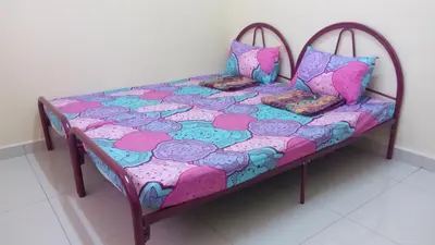 a small bed in a room with aintendent at Taiping Valuable Homestay in Taiping