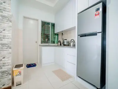 a kitchen with a refrigerator in a white kitchen at Shuang Yang Sekinchan Homestay in Sekincan