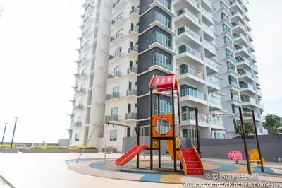 a playground in front of a tall apartment building at Shuang Yang Sekinchan Homestay in Sekincan