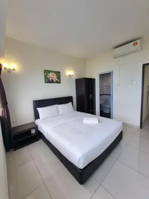 a bedroom with a large white bed in a room at Aloka Seaview Apartment in Batu Ferringhi